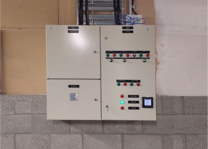 Controls and metering switchboard on gib and grey concrete basement wall 